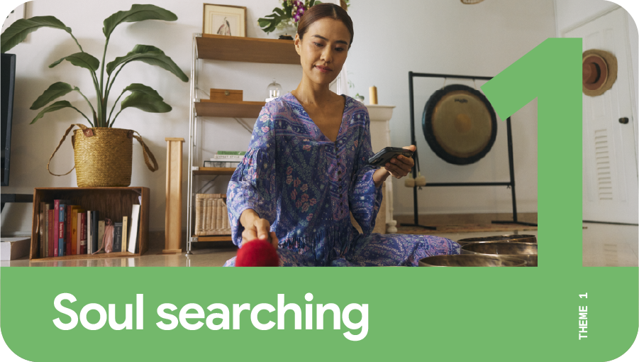 Theme 1: Soul searching. A woman with a phone in one hand practicing gong meditation.