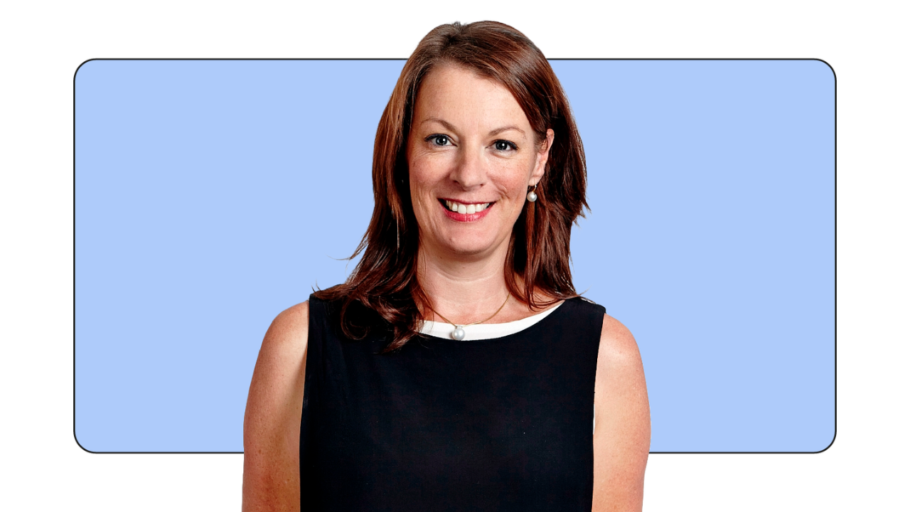 Karen Stocks, VP of global measurement solutions at Google, stands and smiles in front of a light blue rectangle. Stocks has light skin and shoulder-length brown hair, and wears a black sleeveless dress with white detailing at the neckline.